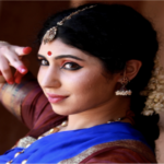 A woman dressed in traditional Indian attire poses gracefully for a photograph, showcasing vibrant colors and intricate designs.